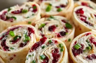 Festive Christmas Cranberry Roll Ups on a serving platter decorated for the holidays.